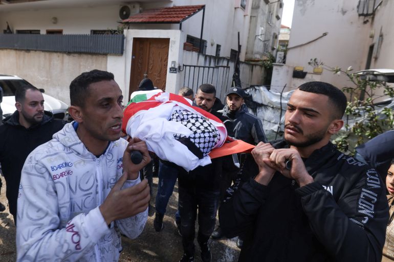 Palestinians carry the body of twenty-one-year-old Omer Al-Swarki during his funeral in the occupied West Bank city of Qalqilya on February 3, 2026 after he was killed while trying to cross the separation wall between Qalqilya and Israel in order to work inside Israel. (Photo by JAAFAR ASHTIYEH / AFP)