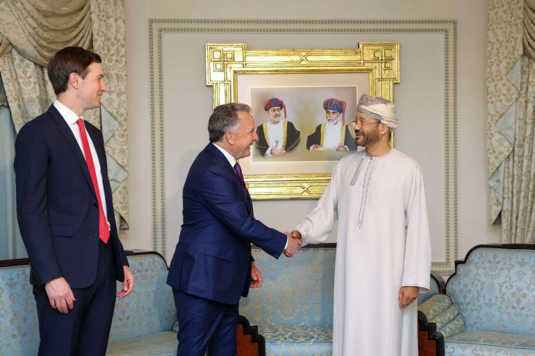 TOPSHOT - In this handout photo released by the Omani Ministry of Foreign Affairs on February 6, 2026, US special envoy Steve Witkoff shakes hands with Oman’s Foreign Minister Badr bin Hamad al-Busaidi as Jared Kushner looks on during a meeting in Muscat.
