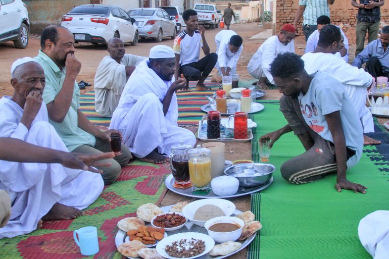 Sudanese people gather for to have their fast-breaking Iftar meal on the first day of Muslim holy fasting month of Ramadan, at a street in Al-Hattana neighbourhood in Omdurman, the twin city of Khartoum on February 18, 2026.
