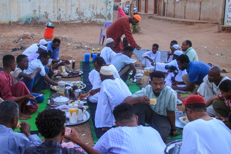 Sudanese people gather for to have their fast-breaking Iftar meal on the first day of Muslim holy fasting month of Ramadan, at a street in Al-Hattana neighbourhood in Omdurman, the twin city of Khartoum on February 18, 2026.
