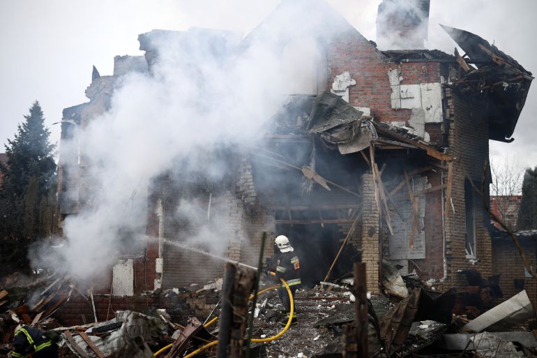 A Ukrainian rescuer works to extinguish a fire in a heavily damaged house following an air attack in Sofiivska Borshchagivka, Kyiv region on February 22, 2026, amid the Russian invasion of Ukraine.