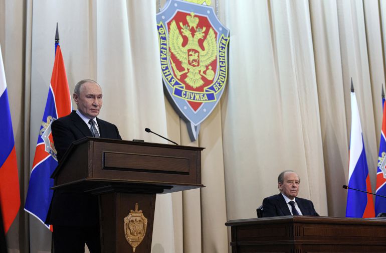 In this pool photograph distributed by the Russian state agency Sputnik, Russia's Federal Security Service Director Alexander Bortnikov (R) listens to Russia's President Vladimir Putin (L) as he gives a speech during a meeting of the Federal Security Service Board in Moscow on February 24, 2026.
