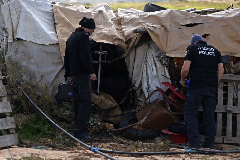 Israeli security personnel inspect debris at the site where tents and vehicles of Palestinians were reportedly set on fire by Israeli settlers from a nearby settlement, in Susya village, south of Hebron in the Israeli-occupied West Bank, on February 25, 2026.