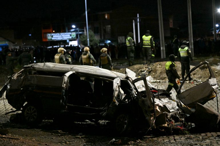 afp_69a250e9b890-1772245225 A destroyed car is pictured near the site where a military plane crashed in el Alto, near La Paz on February 27, 2026.