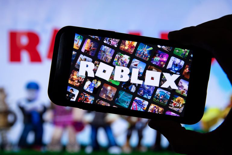 fghyf-1770025356 LONDON, UK - March 2021: Person holding a smartphone with Roblox game logo