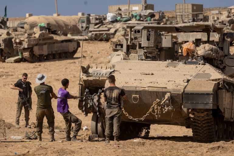 SOUTHERN ISRAEL, ISRAEL - OCTOBER 29: Israeli soldiers fix an armored personnel carrier near the border with the Gaza Strip on October 29, 2025 in Southern Israel, Israel. Israeli Prime Minister Benjamin Netanyahu ordered "immediate, powerful" strikes on Gaza Tuesday, after his office accused Hamas of violating the terms of the ceasefire agreement for returning remains that Israel says do not belong to any of the 13 unaccounted for hostages. The announcement of strikes followed reports of fighting in Rafah near the "yellow line" demarcating territory under IDF control in Gaza, according to the US-brokered ceasefire agreement that came into affect on October 10. (Photo by Amir Levy/Getty Images)