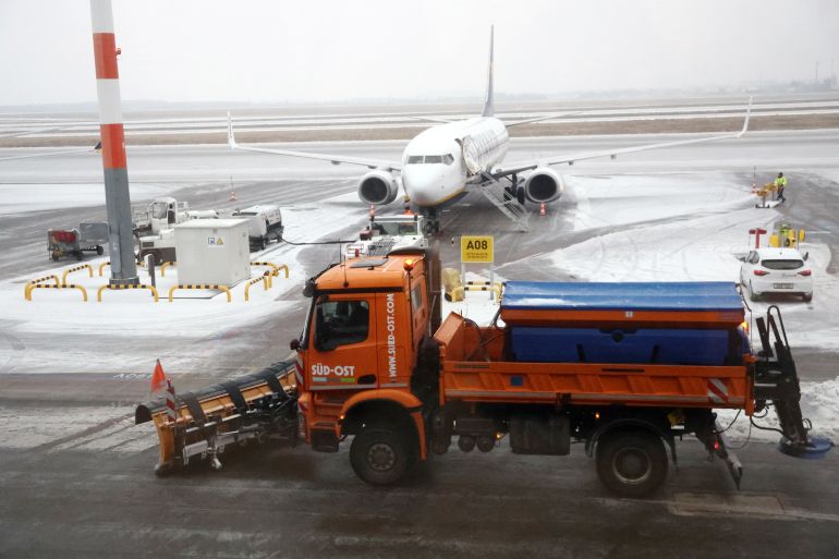 SCHOENEFELD, GERMANY - FEBRUARY 05: A snowplow drives past at Berlin Brandenburg Airport on February 05, 2026 in Schoenefeld, Germany. Flights have been cancelled or delayed due to snow and freezing rain. (Photo by Maryam Majd/Getty Images)
