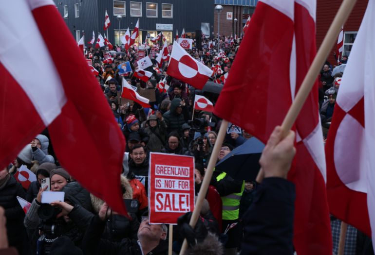 NUUK, GREENLAND - JANUARY 17: People bear Greenlandic flags as they gather to march in protest against U.S. President Donald Trump and his announced intent to acquire Greenland on January 17, 2026 in Nuuk, Greenland. Greenlandic, Danish and other European leaders are hoping they can still avert an intervention by the United States to forcefully acquire the island as U.S. President Donald Trump continues to insist the U.S. must have Greenland, suggesting even by military means if necessary. (Photo by Sean Gallup/Getty Images)