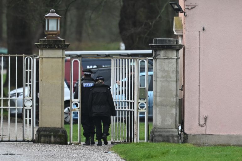 getty_699d3edb33-1771912923 WINDSOR, ENGLAND - FEBRUARY 20: Police officers approach the gates of the Royal Lodge, Andrew Mountbatten-Windsor's former residence in Windsor Great Park, February 20, 2026 in Windsor, England. The former Prince Andrew was arrested yesterday at his new residence on the Sandringham estate on suspicion of misconduct in public office. In a statement, Thames Valley police said they were also "carrying out searches at addresses in Berkshire and Norfolk" as part of the investigation. The Berkshire property is believed to be the Royal Lodge. (Photo by Leon Neal/Getty Images)