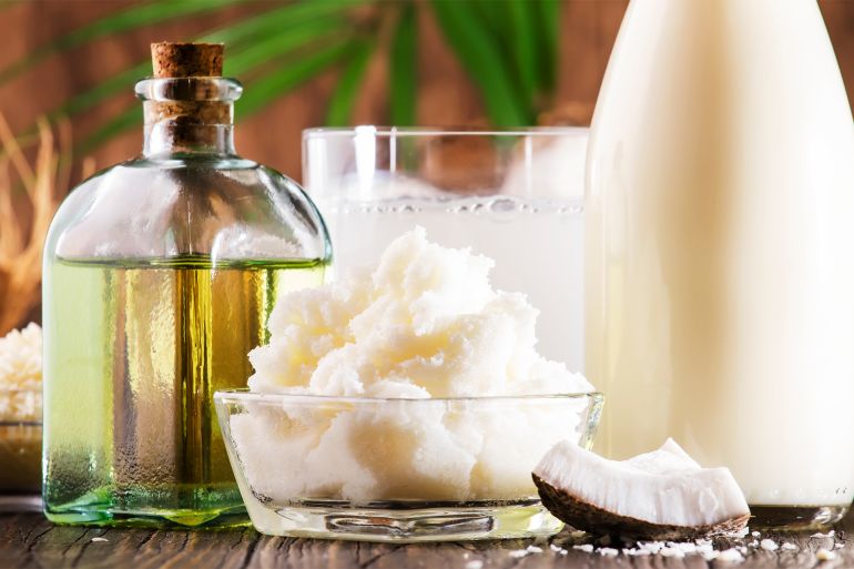 Coconuts products - mct butter, oil, milk, shavings on wooden table background. Hair, skin and body treatment and healthy food concept - stock photo Coconuts products - mct butter, oil, milk, shavings on wooden table background. Hair, skin and body treatment and healthy food concept