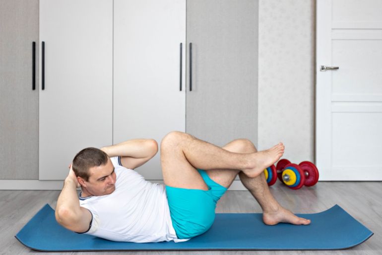 A strong, healthy man with muscles, training at home. Exercises for the muscles of the press.