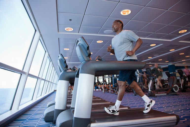 Retired man jogging on a treadmill on a cruise ship