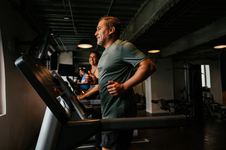 Mature man on treadmill at gym