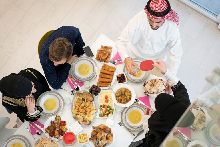 Muslim family and friends at Ramadan Iftar food table