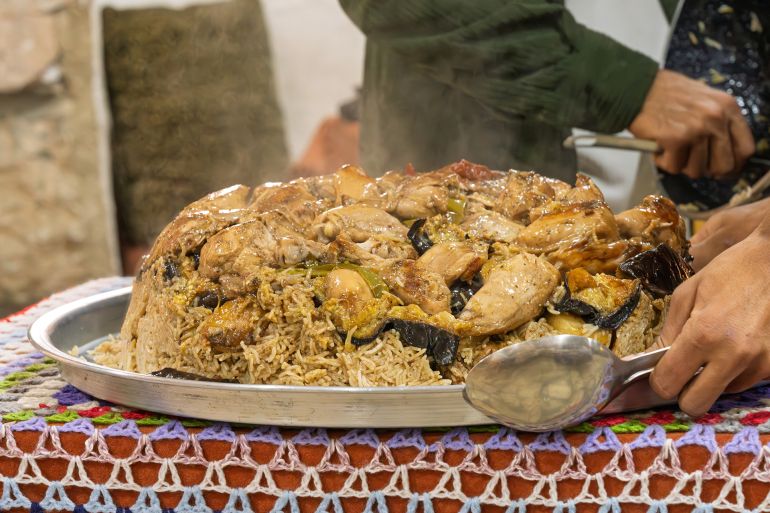 Maqluba features tender chicken, rice, and vegetables layered in a pot and flipped dramatically onto a serving platter
