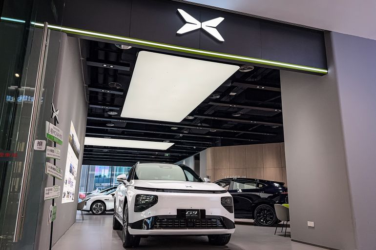 CHONGQING, CHINA - MAY 20: XPeng G9 electric SUVs are displayed inside an XPeng showroom, with the company's distinctive logo and modern showroom design visible, on May 20, 2025 in Chongqing, China. XPeng continues to ramp up its presence in the premium electric SUV segment, amid rising demand for intelligent driving technologies and growing international expansion. (Photo by Cheng Xin/Getty Images)
