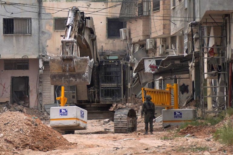 الجيش الإسرائيلي يثبيت بوابة حديدية عند أحد مداخل مخيم جنين في الضفة الغربية المحتلة، 23 أبريل/نيسان 2025."