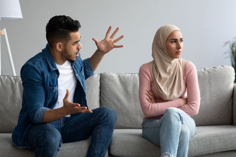 ramdan1-1772020219 Relationships problems and crisis concept. Angry arab man and woman in hijab fighting at home, sitting on sofa and having quarrel, copy space. Furious middle eastern guy yelling at upset girlfriend