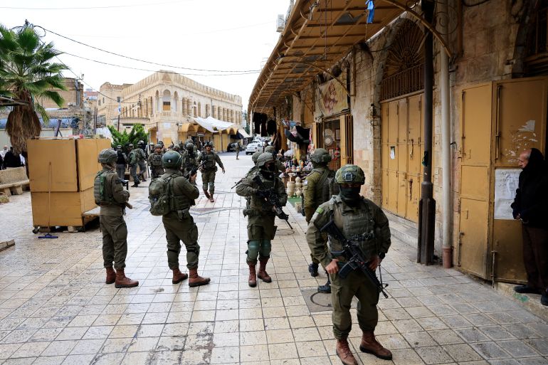 reuters_6963600d-1768120333-1 Israeli soldiers stand guard during a weekly settlers' tour in Hebron, in the Israeli-occupied West Bank, January 10, 2026. REUTERS/Mussa Qawasma