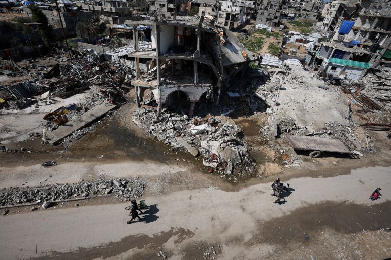 Palestinians walk past the rubble of residential buildings destroyed during Israel's two-year offensive, in Gaza City, February 4, 2026. REUTERS/Dawoud Abu Alkas TPX IMAGES OF THE DAY
