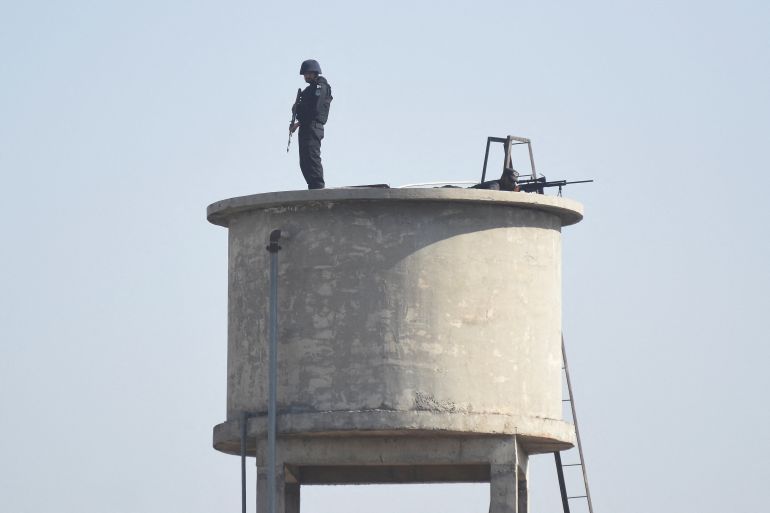 Police officers stand guard on a water tank during a funeral for victims following the suicide explosion at a Shi'ite Muslim mosque, in Islamabad, Pakistan, February 7, 2026. REUTERS/Waseem Khan