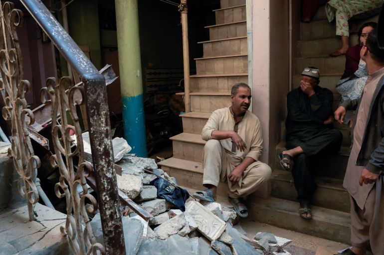 reuters_6996f59d-1771500957 Residents sit beside debris after a gas cylinder blast caused a portion of a residential building to collapse in Karachi, Pakistan February 19, 2026. REUTERS/Akhtar Soomro