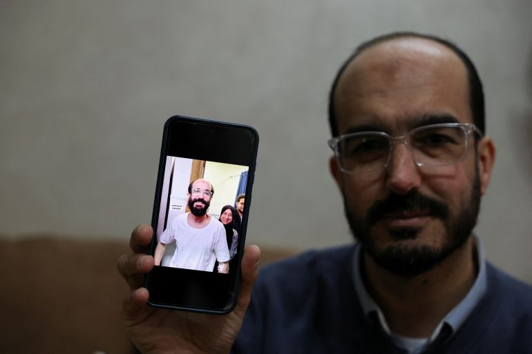 Samer Khaweireh, 45, shows a photo of how he appeared the day he was released from prison four weeks ago after he said he lost 22 kilos of weight in nine months, as he sits in his home in Nablus in the Israeli-occupied West Bank, February 11, 2026.REUTERS/Ammar Awad