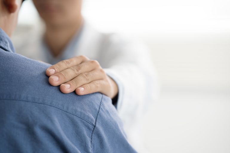 Doctor or psychiatrist shakes hands encouragement the patient and care having a consultation on diagnostic examination on male disease or mental illness in a clinic or hospital mental health service
