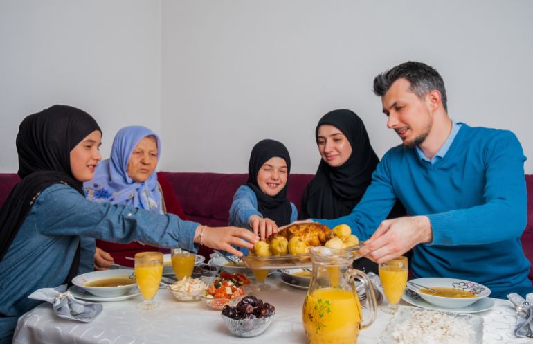 Happy Muslim family having iftar dinner to break fasting during Ramadan dining table at home.; Shutterstock ID 2258544091; purchase_order: ajnet; job: ; client: ; other: