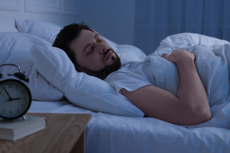 Handsome man sleeping in bed at night