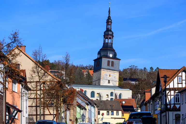 02 December 2025, Thuringia, Bad Frankenhausen: With an inclination of now 4.86 meters, the tower of the Oberkirche rises above the rooftops in Bad Frankenhausen. This makes the church tower leaner than the famous Tower of Pisa (Italy), which leans 3.92 meters. After several years, the leaning tower of the Oberkirche will be accessible to visitors again from next spring. In future, 15 guests will be able to climb the tower at the same time every half hour and enjoy the panoramic view over the spa town and the Kyffhäuser mountains on a small skywalk. In the new visitor center, an immersive cinema and VR glasses will bring the history of the tower to life digitally. Around 12.8 million euros have been invested in the tourist development of the quirky landmark. Around 80,000 visitors are expected every year in the future. Photo: Hendrik Schmidt/dpa (Photo by Hendrik Schmidt/picture alliance via Getty Images)