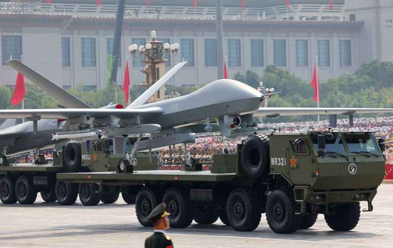 A member of the People's Liberation Army stands as unmanned aerial vehicles are displayed during a military parade to mark the 80th anniversary of the end of World War Two, in Beijing, China, September 3, 2025. REUTERS/Maxim Shemetov REFILE - QUALITY REPEAT