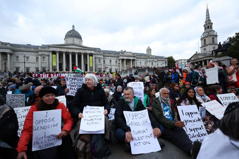 2ion-1761042680 Protesters hold placards during a mass demonstration organised by Defend our Juries, against the British government's ban on Palestine Action, at Trafalgar Square in London, Britain, October 4, 2025. REUTERS/Toby Melville