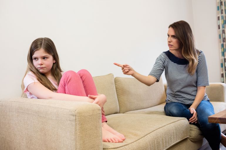 Daughter ignoring her mother after an argument in living room at home فري بيك