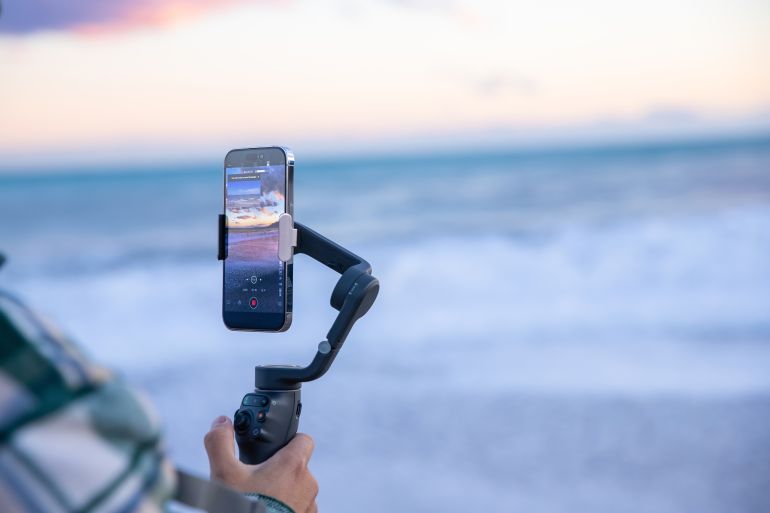 5d8b4d8b3d98ad8b4d8b3d98ad8b4-1761568364 Antalya, Turkiye - November 21, 2024. Close-up of cameraman shooting video to learn the features of DJI gimbal on iPhone 16 Pro.