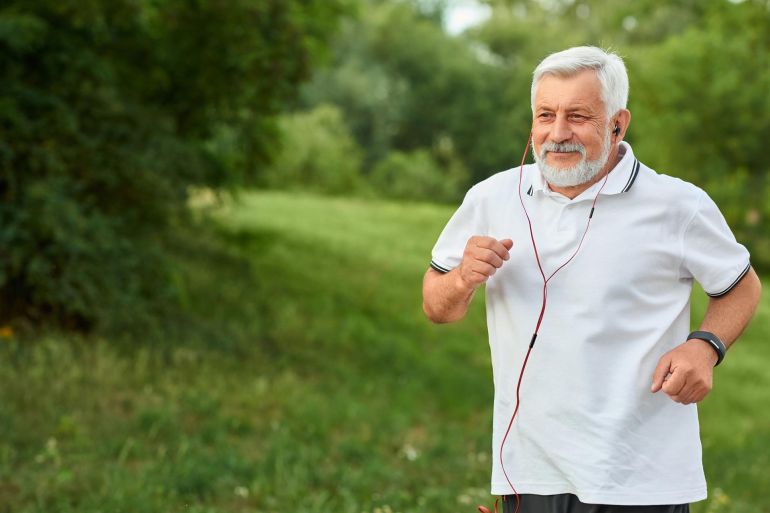 Smiling running old man in green city park @فري بيك