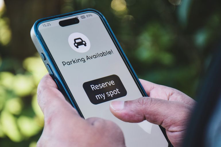 Man making parking reservations for his car online. Vehicle parking booking system using mobile applications concept.