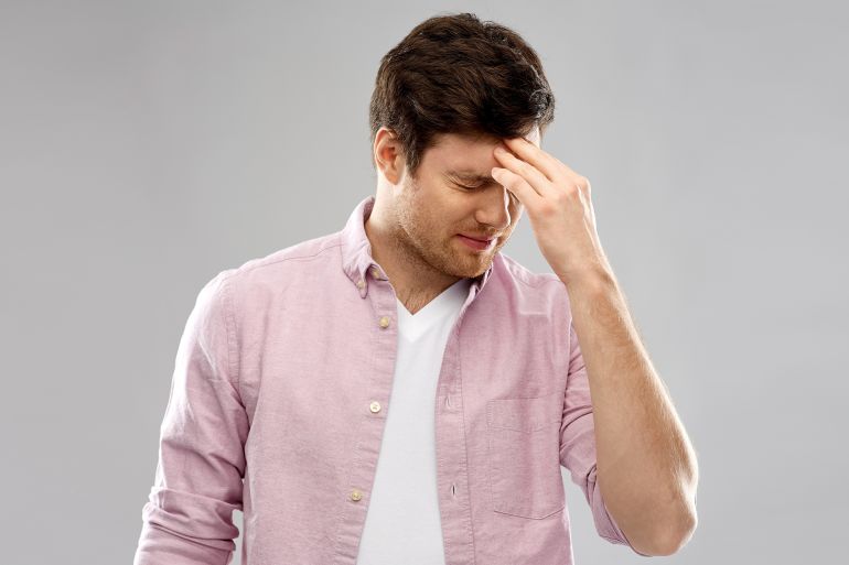 mind, health problem and stress concept - unhappy indian man suffering from headache over grey background by Syda Productions @ادوبي ستوك