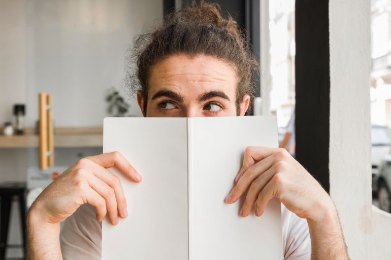 Man enjoying the smell of a book freepik