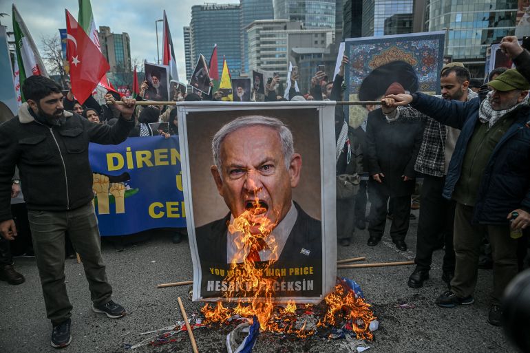 TOPSHOT - Protestors set fire to an image depicting Israeli Prime Minister Benjamin Netanyahu as they gather to protest against the US and Israel attack of Iran and the killing of the Supreme leader in front of Israel Consulate in Istanbul on March 1, 2026.