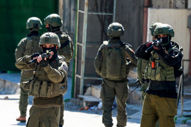 TOPSHOT - Israeli soldiers patrol a street during a military operation in the Askar refugee camp in eastern Nablus, Israeli-occupied West Bank, on March 2, 2026.