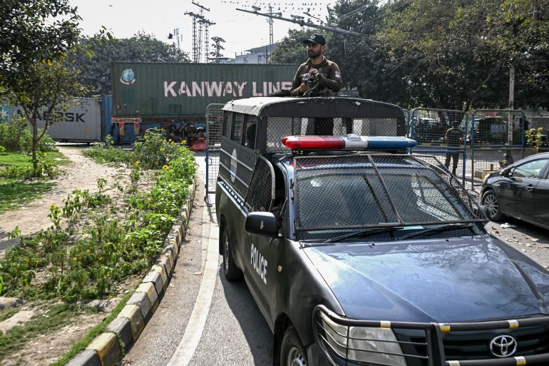 afp_69a5b17bc3de-1772466555 A policeman stands guard as containers are placed in front of the road leading to the US Consulate in Lahore on March 2, 2026 following violent demonstrations a day earlier across Pakistan.