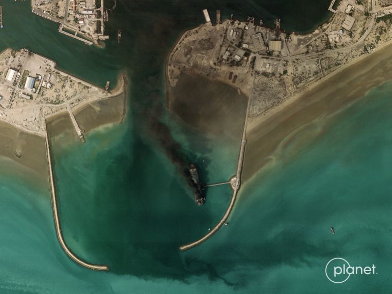 afp_69a7d999e205-1772607897 TOPSHOT - This handout satellite image taken by 2026 Planet Labs PBC on March 2, 2026 shows smoke billowing from a vessel following an explosion from the port of Bandar Abbas along the strait of Hormuz.