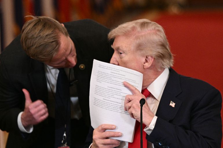 US President Donald Trump speaks with a secret service agent during a roundtable to "save college sports" in the East Room of the White House in Washington, DC, on March 6, 2026. (Photo by Brendan SMIALOWSKI / AFP)