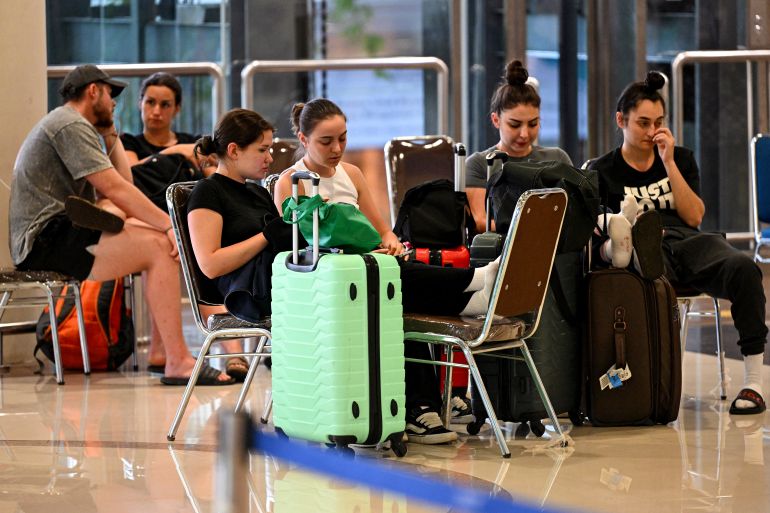 Passengers wait amid flights disruptions as a result of the Israeli-US strikes on Iran, at Ngurah Rai International Airport on Indonesia's resort island of Bali, on March 2, 2026. (Photo by SONNY TUMBELAKA / AFP)
