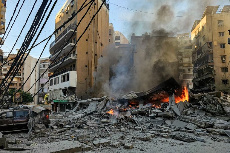 TOPSHOT - A fire burns at the site of a collapsed building following an Israeli airstrike on Beirut's southern suburbs on March 9, 2026.