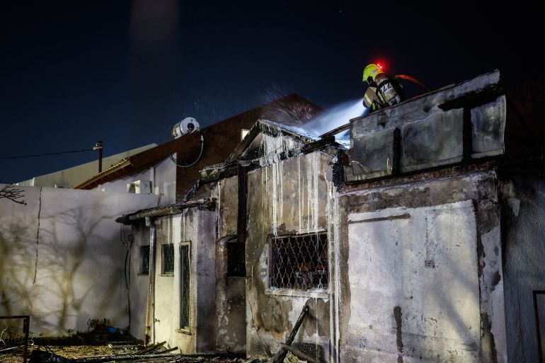 A firefighter works at the site of a strike in the northern Israeli city of Nahariya on March 16, 2026.