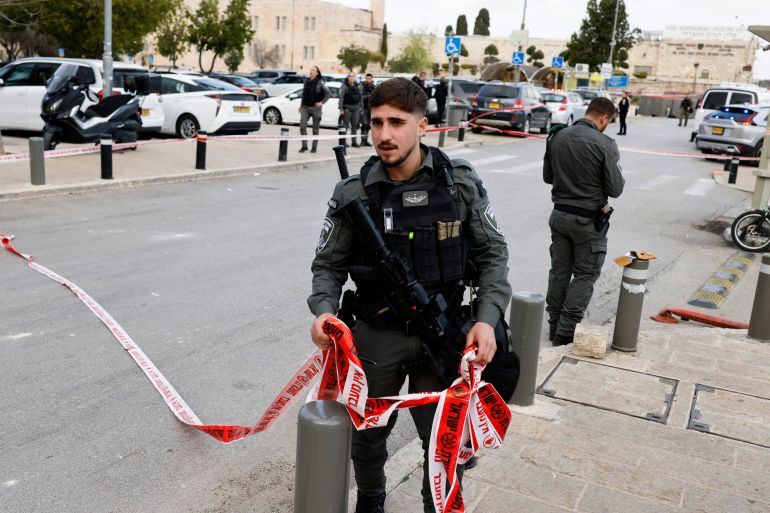 afp_69bd6bdd5315-1774021597 An Israeli soldier ties red tape close to the scene after an impact or the remains of an intercepted projectile fell inside the walls of the Old City of Jerusalem on March 20, 2026, as Muslim citizens celebrate Eid al-Fitr marking the end of the holy month of Ramadan.