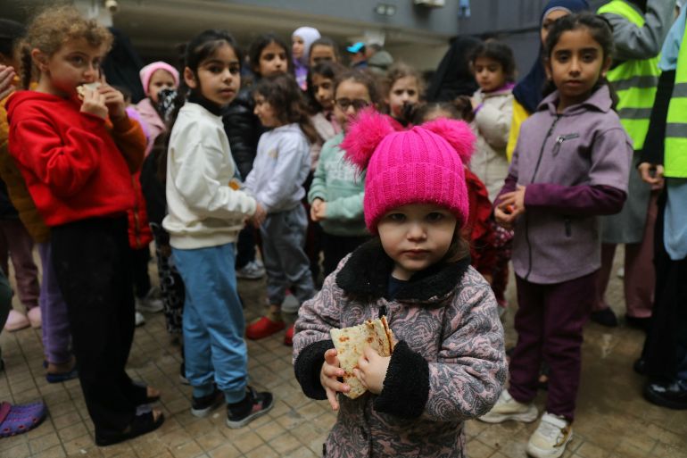 afp_69be9b6c2542-1774099308 Displaced children from southern Lebanon eat manakish in the playground of a school turned into a shelter in Beirut on March 21, 2026.