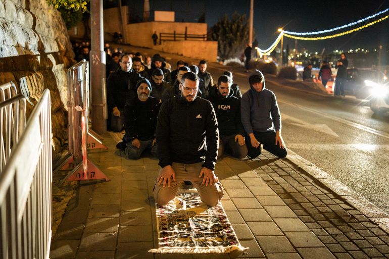 Muslim worshippers perform the Tarawih prayers during the Muslim holy month of Ramadan along a road outside the old city walls of Jerusalem on March 17, 2026, while the Aqsa mosque compound remains closed.